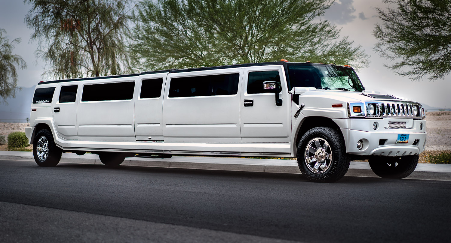 A white limo is parked on the side of the road.