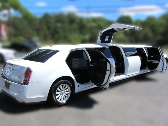 A white limo is open and ready to take passengers.